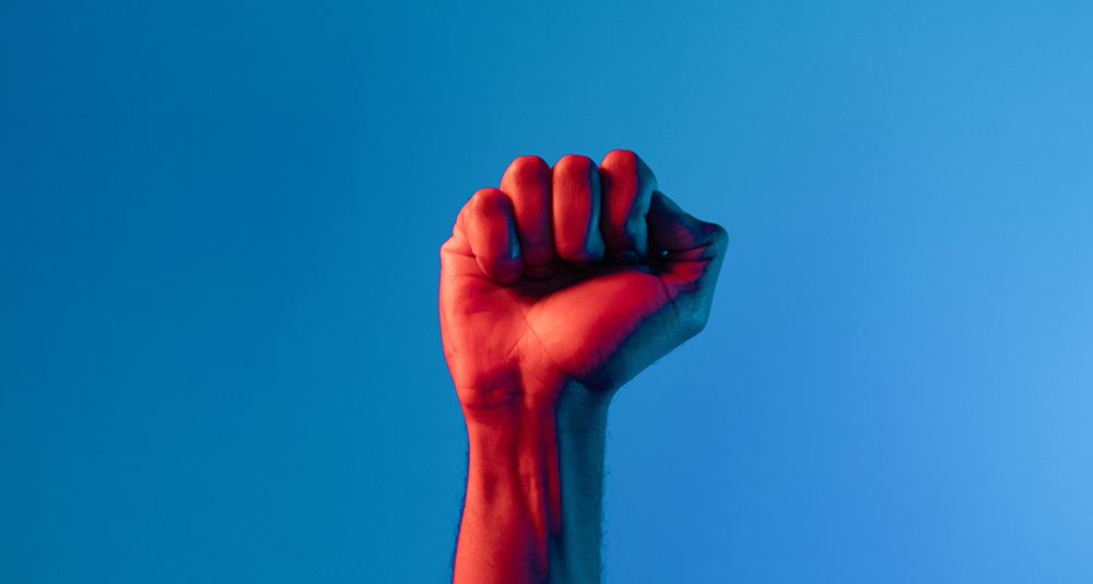 Photo by VAZHNIK: https://www.pexels.com/photo/persons-fist-up-in-blue-background-7561648/